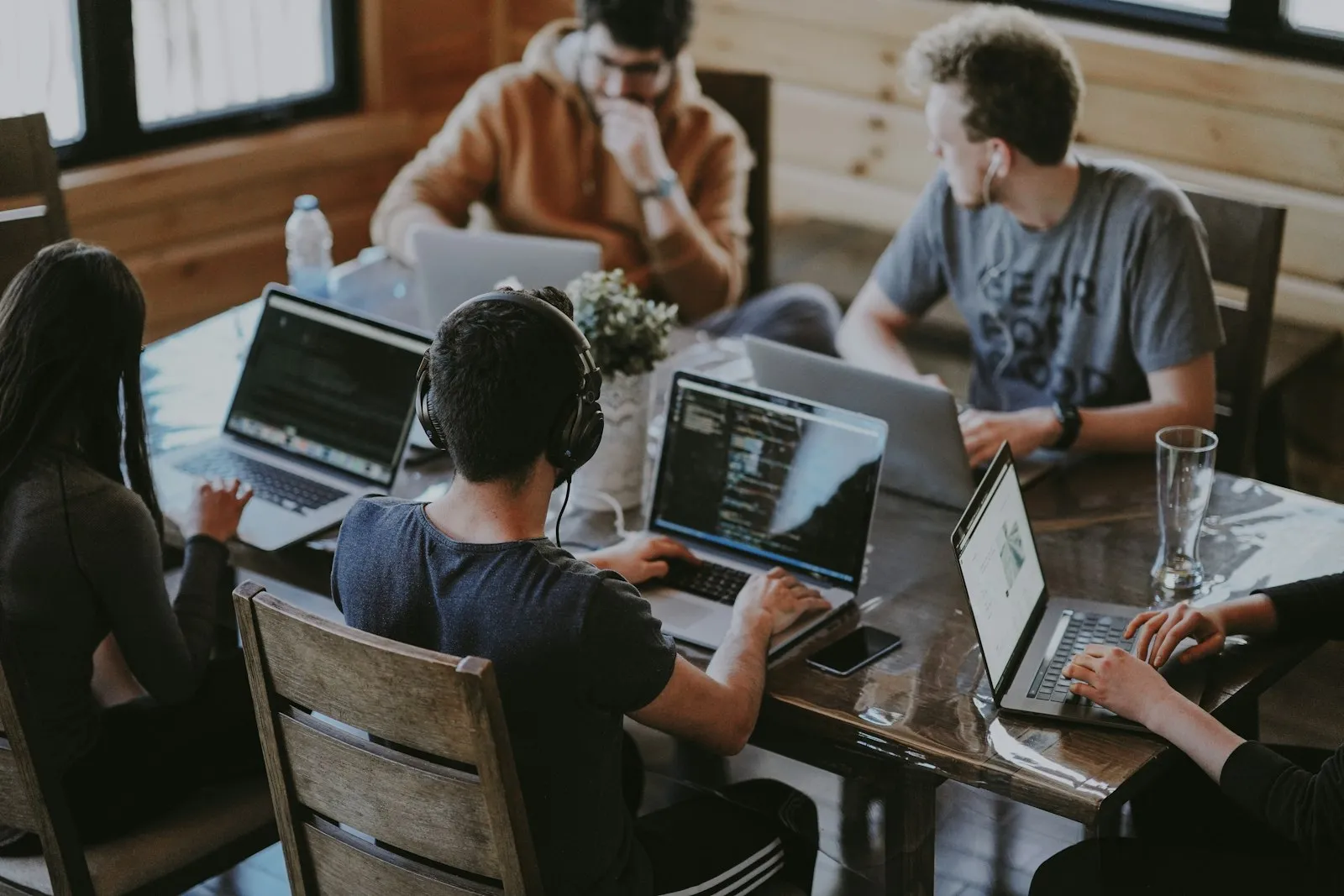 Studio team collaborating around a table with laptops